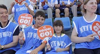 Image: Photograph of children among the supporters. Sitting between their parents, they are smiling at the camera.