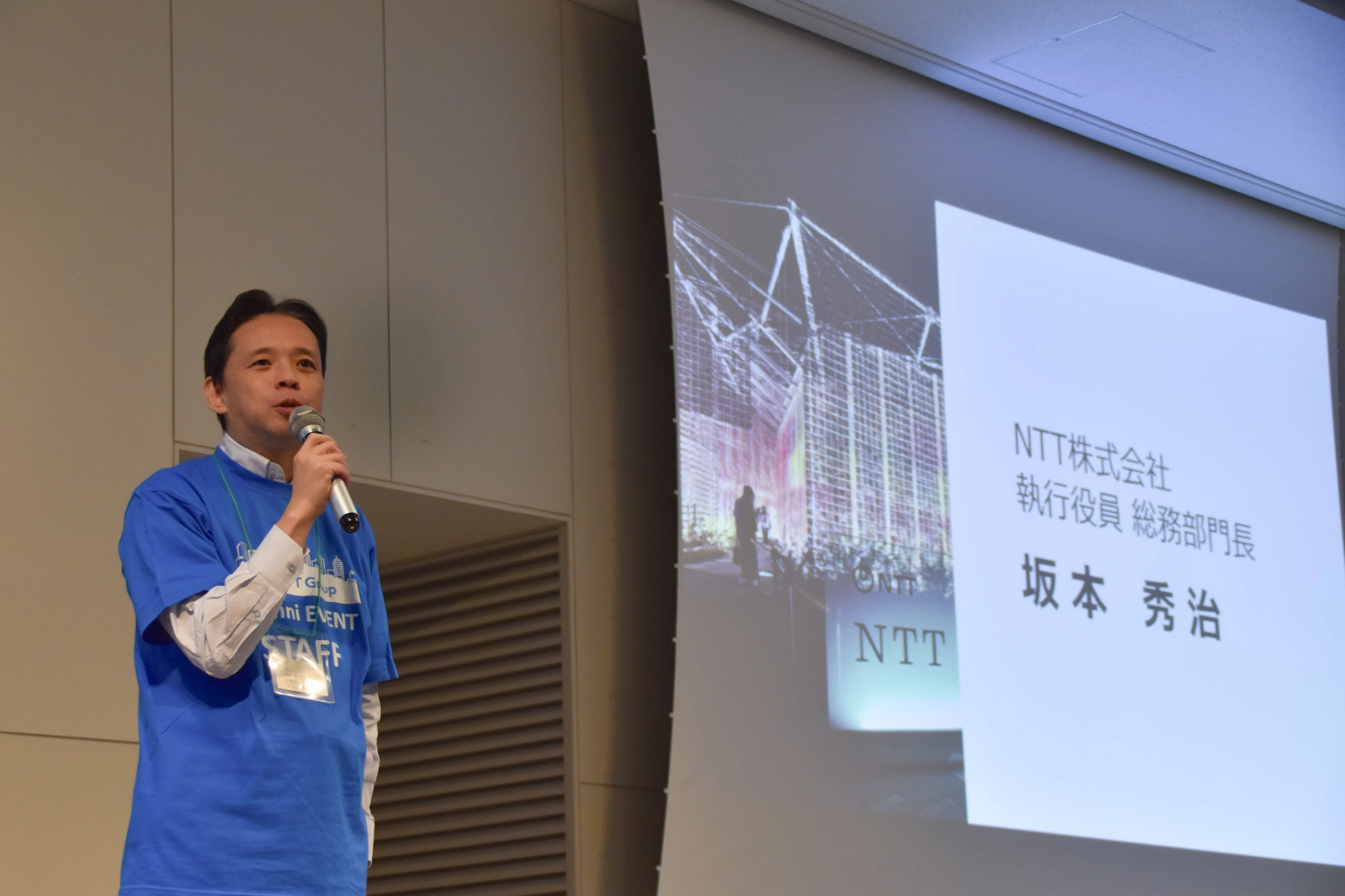 写真：開会あいさつをするNTT 総務部門長坂本秀治
