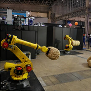 黄色いロボットアームが米俵を持ち上げている写真