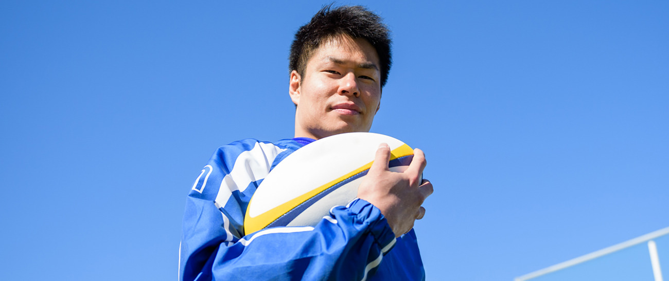 画像：ラグビーボールを持つ羽野 一志選手の写真。