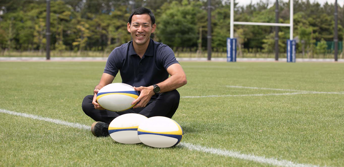 画像：グラウンドでラグビーボールを持った、笑顔の川原さん