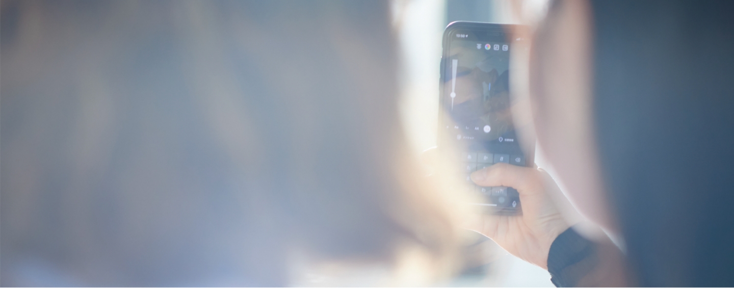 若者がスマートフォンを操作している様子の写真②