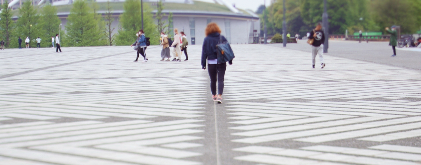 道を歩く若者の後ろ姿の写真