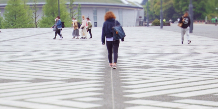 道を歩く若者の後ろ姿の写真